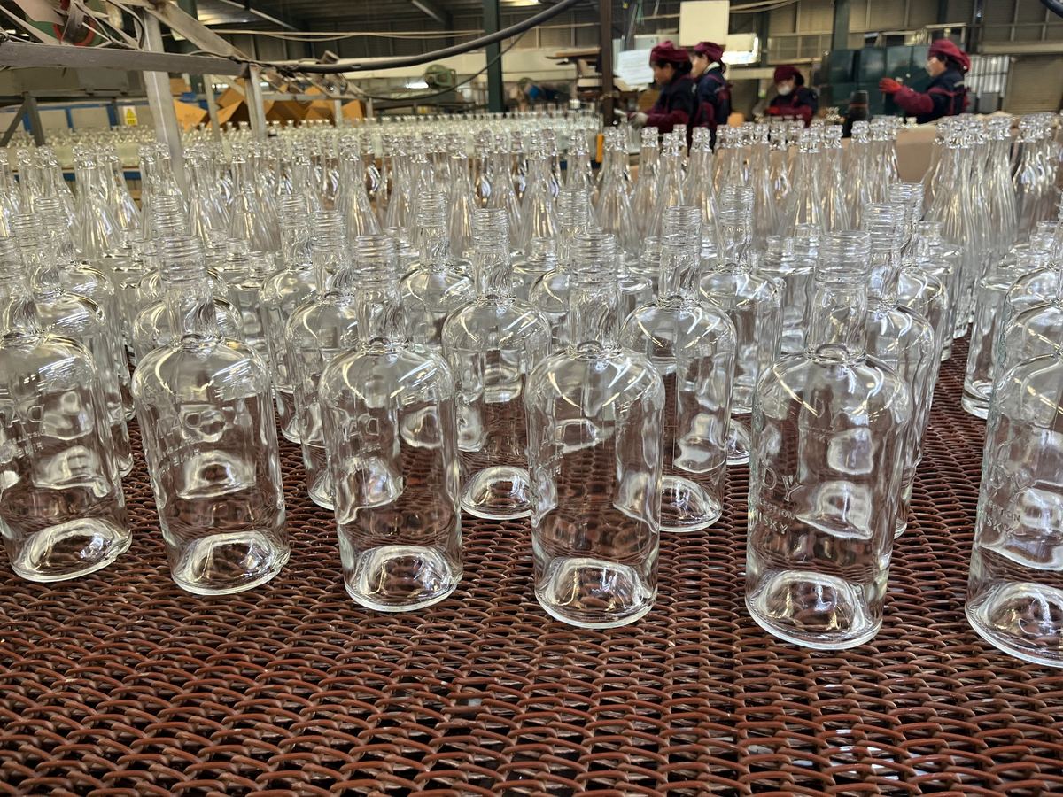 Finished clear glass spirits bottles with heavy base and embossing potential for premium packaging